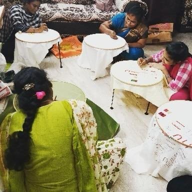Students hand-working Aari embroidery on hoops at Vinu Fashion Academy